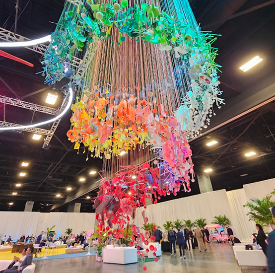 Colorful hanging art installation above a large event floor
